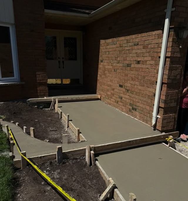 Wood forms and fresh concrete for a walkway to a front door