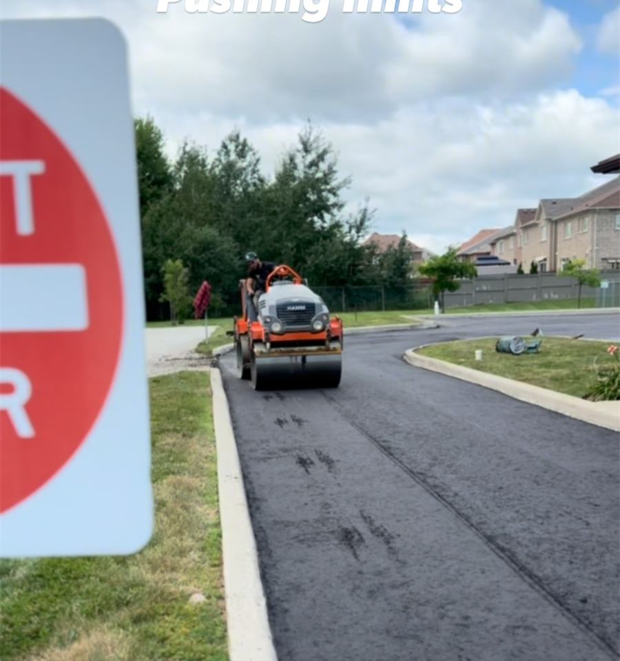 Freshly paved black road beside a stop sign
